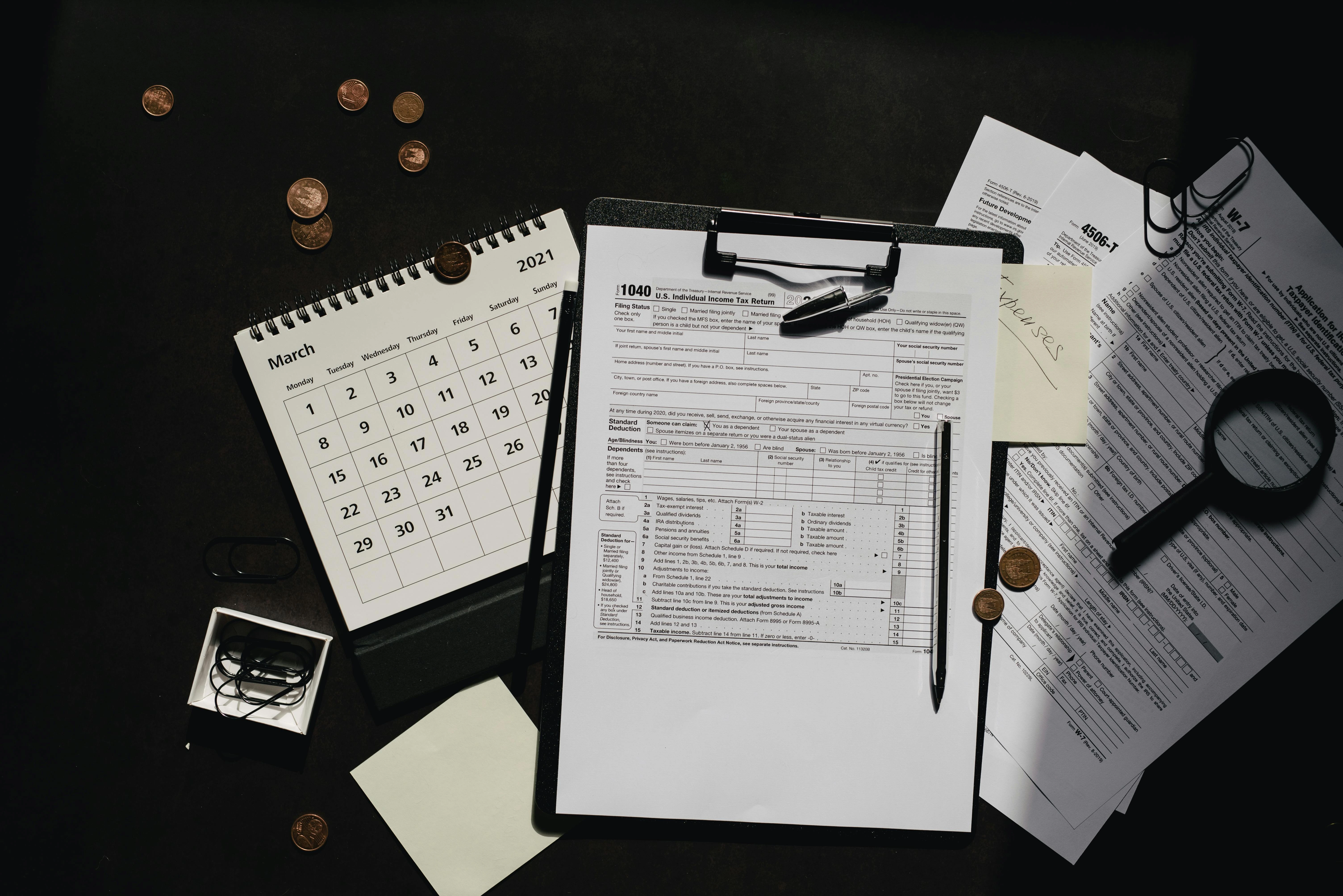 A person at a desk with a calculator, planning their finances for the CMA exam.