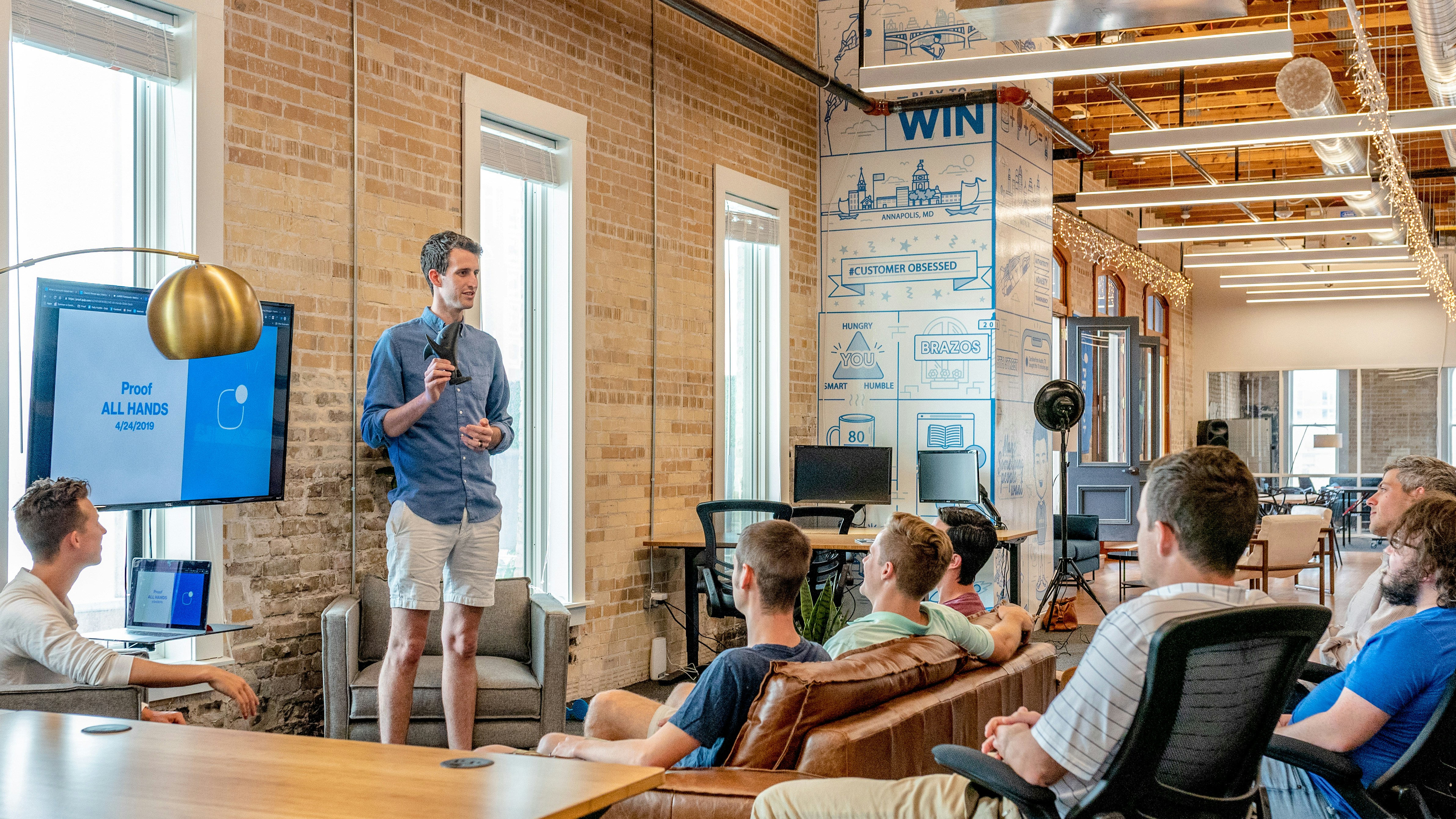 A team of professionals in a meeting room, discussing strategy around a table.